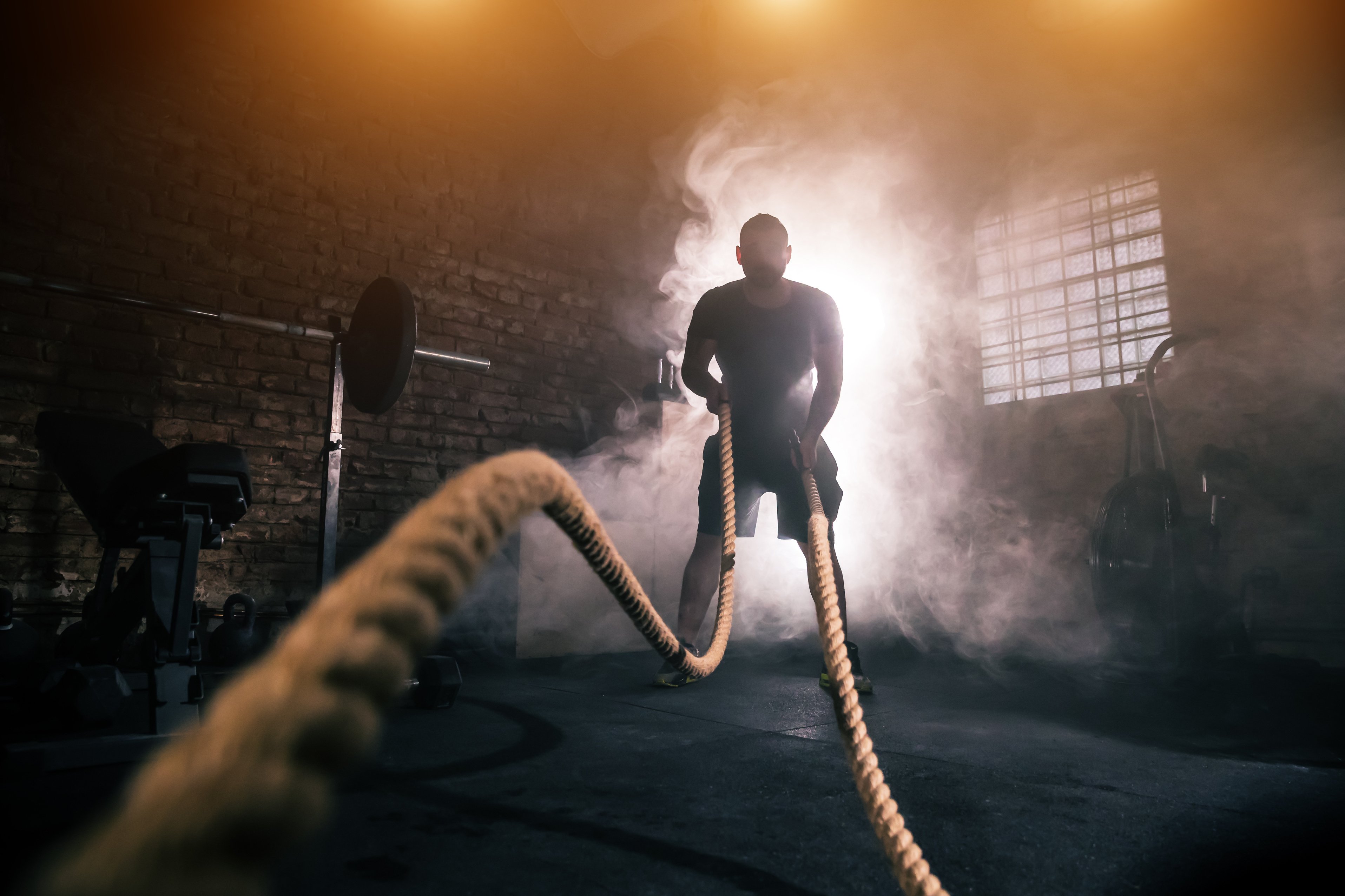 Young man doing hard exercise workout in gym